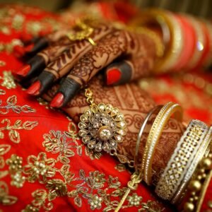 Close-up of ornate henna designs and traditional jewelry on a bride's hands, highlighting Indian wedding elegance.